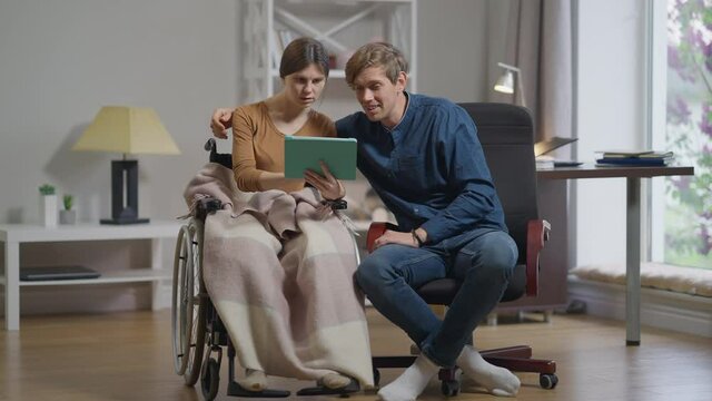 Front view happy couple gesturing high-five in slow motion rejoicing at home. Disabled Caucasian woman and cheerful man in living room indoors. Relationship and medical concept