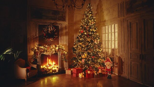 Christmas and New Year interior decoration. Green tree decorated with toys, gifts, present boxes, flashing garland, illuminated lamps. Fireplace with burning fire. Cozy Christmas atmosphere. 4K Loop