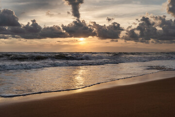 Sea splashing waves in the setting sun and beautiful cloudy sky background. Travel and tourism concept. Nature background. Great wallpaper design. Copy space.