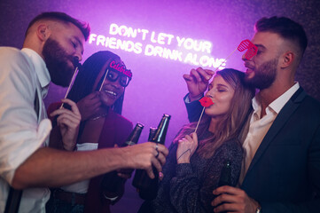 Happy group of friends dancing on a party in a club