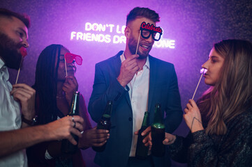 Happy group of friends dancing on a party in a club