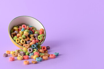 Bowl with crunchy corn flakes rings on color background