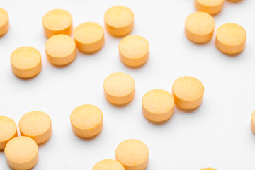 Many vitamin A pills scattered on white background, closeup
