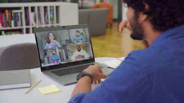 Indian man using app for distance video communication with coworkers by laptop