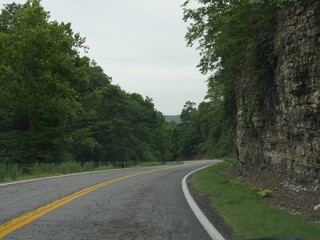 Fototapeta na wymiar Winding asphalt road with rock walls on one side