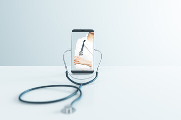 Close up of abstract creative blank phone screen with stethoscope on light background with mock up place. Online medicine, ask a doctor concept. 3D Rendering.