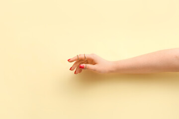 Young woman with beautiful manicure and stylish rings on color background
