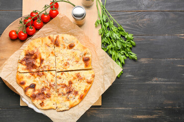 Board with delicious khachapuri and spices on wooden background