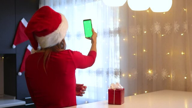 A girl suit in the kitchen leafs through a smartphone