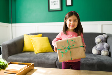 Cheerful little girl opening a present