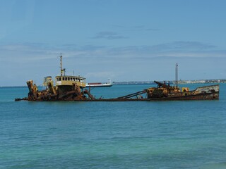 Wide shot of the rusty remnants of an old vessel docked at Georgetown, Great Exumas in the Bahamas.