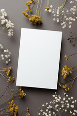 Invitation or greeting card mockup with dry flowers twigs on grey