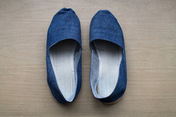 Un par de sandalias azules sobre madera.