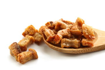 Spoon with tasty cracklings on white background, closeup