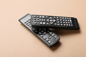 Modern TV remote controllers on color background