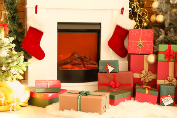 Fireplace with Christmas socks and gift boxes in room