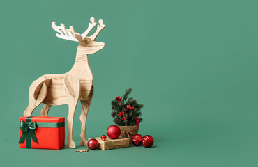 Wooden reindeer with small Christmas tree and gifts on green background © Pixel-Shot