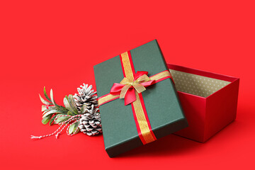 Opened gift box and Christmas decor on red background