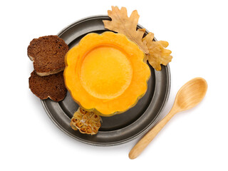 Tasty soup served in pumpkin with bread on white background
