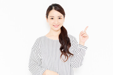 指でポイントを指し示すカジュアルな服装の女性