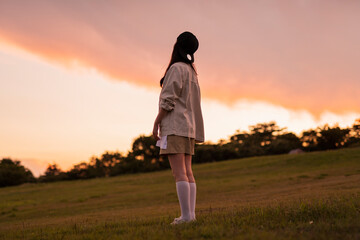 夕方のキャンプ場に立つ女性