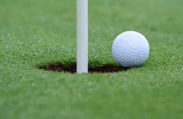 pelota de golf apunto de caer al hoyo