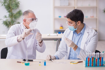 Two male chemists working at the lab during pandemic