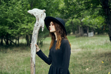 woman in black witch costume in forest nature posing