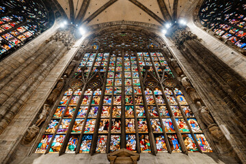 Colored stained glass windows illuminated from above in the Duomo. Italy, Milan