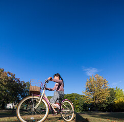 秋の公園で自転車を乗って遊んでいる可愛い子供