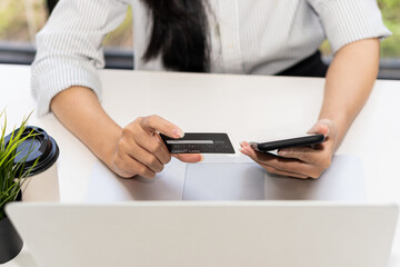 young woman holding credit card and using a laptop computer online shopping, e-commerce, internet banking, spending money, work from home concept and online payment close