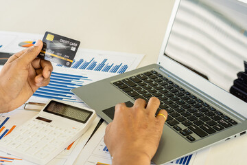 young woman holding credit card and using a laptop computer online shopping, e-commerce, internet banking, spending money, work from home concept and online payment close