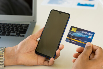 young woman holding credit card and using a laptop computer online shopping, e-commerce, internet banking, spending money, work from home concept and online payment close