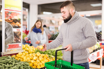 Male customer buying lemon at supermarket. High quality photo
