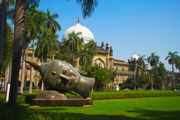 Buddha head carvings on the green grass of the museum. The Prince of Wales Museum (Chhatrapati Shivaji) is located in Mumbai, Maharashtra, India.