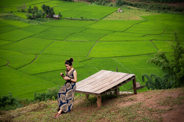 Happy young woman traveler standing with raised arms and enjoying a beautiful nature