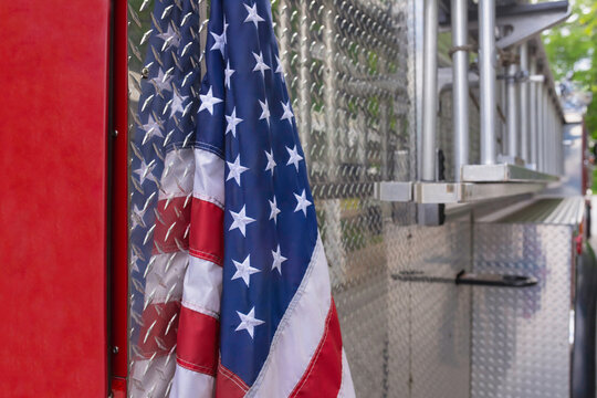 American Flag Hangs on Back of Red and Silver Firetruck