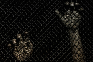 closeup of hand in jail, hands on a black background, a prisoner behind bars, trapped