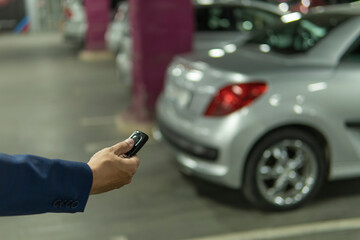 Close up hand a man Press the button of car keys remote for lock and unlock car door