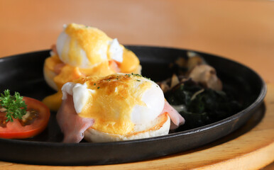 Closeup of egg with ham and bread in hot plate.