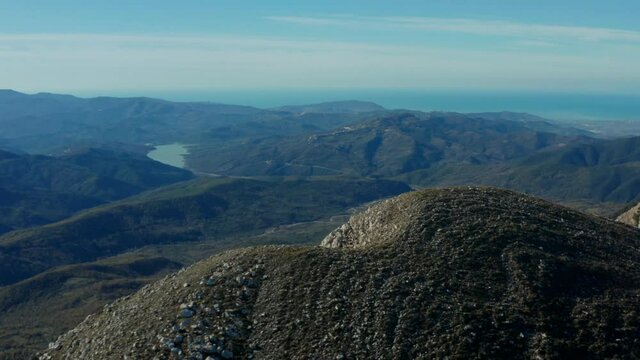 Aerial view over a mountain range, high up in the alpines of Campania, Italy, sunny day - tracking, drone shot