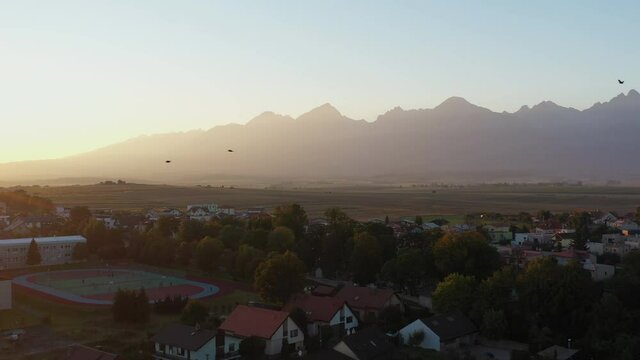 Cinematic drone shot of the High Tatras mountains in Poprad, Slovakia with birds flying in the foreground