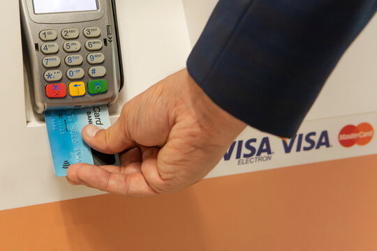 man pays with a credit card for purchases at the pos terminal
