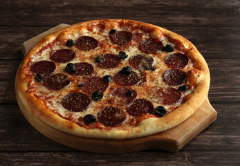 pepperoni pizza with sausage and olives on a dark wooden background
