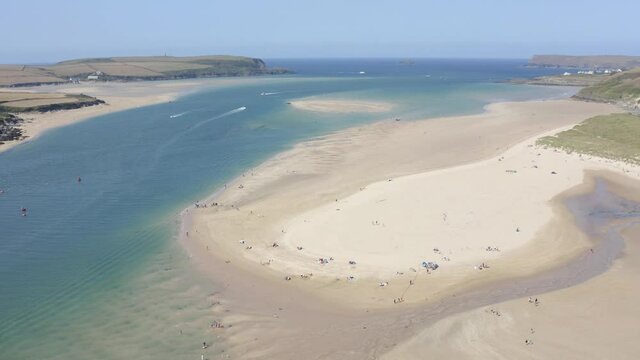 Flying over beautiful sandy beach, aerial seaside landscape with sea and waves, rocky cliffs in the background.Cinematic drone and aerial footage over Porthtowan Beach in North Cornwall.