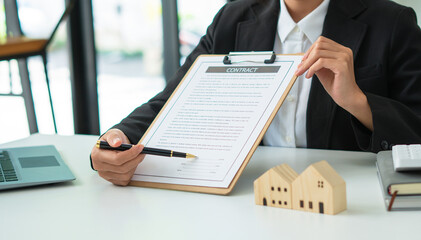 Buying a Home or Insurance, an insurance agent explains the lease agreement to a client before...