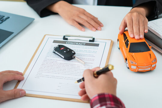 Man Signing Car Insurance Document Or Lease Paper. Writing Signature On Contract Or Agreement. Buying Or Selling New Or Used Vehicle. Car Keys On Table. Warranty Or Guarantee. Customer Or Salesman.