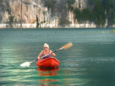 Mature Woman  Floating On Kayak On Cheow Lan Lake, Khao Sok National Park, Thailand