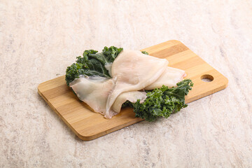 Raw squid over wooden board
