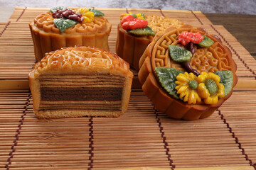 Colorful flower decorated mooncake cut slice half layer Chinese mid autumn festival on bamboo food mat background